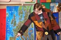 Jedna z aktorek przedstawienia „Kot w butach” stoi przy mapie Europy i wskazuje na Francję.