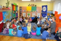 Zabawa z dziećmi po przedstawieniu „Kot w butach”. Aktorki przedstawienia, nauczycielki przedszkola oraz dzieci siedzą razem w kółku na dywanie.