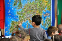 Jeden z przedszkolaków stoi przy mapie Europy i wskazuje na Francję.