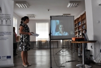 Czytelnia Czasopism Wojewódzkiej Biblioteki Publicznej w Olsztynie. Anita Romulewicz prezentuje na dużym ekranie nagranie filmowe z podziękowaniem Izabeli Aftyka, jednej z laureatek konkursu „Moje korzenie, czyli skąd jestem”. 