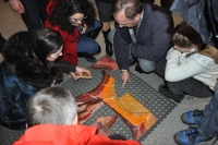 zdjcie przedstawia uczestnikw wernisau ukadajcych ceramiczn mozaik Barbary Kokoryn 