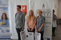 Na zdjciu trzej laureaci konkursu, od prawej dwie dziewczynki i jeden chopiec, trzymajcy w rkach torby z upominkami i logo konkursu. Za nimi roll-upy Wojewdzkiej Biblioteki Publicznej w Olsztynie oraz Wojewdztwa Warmisko-Mazurskiego.