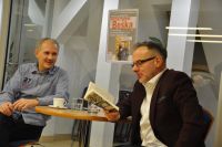 Na zdjciu siedz przy stole: po lewej stronie prowadzcy spotkanie Robert Lesiski, po prawej Krzysztof Beka. Krzysztof Beka czyta trzyman w rku ksik.