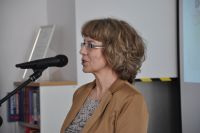 Anna Głowińska (Kierownik Miejskiej Biblioteki Publicznej w Ostródzie działającej w strukturze Centrum Kultury) stoi przy mównicy i przemawia do mikrofonu.