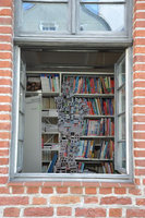 ceramika Katarzyny Miściur w oknie Wypożyczalni Literatury Pięknej i Obcojęzycznej, w tle regał z książkami