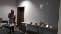 dr hab. Krzysztof D.  Szatrawski, obok na ekranie wyświetlone zdjęcie artysty, poniżej płyty z twórczością Wojciecha Młynarskiego