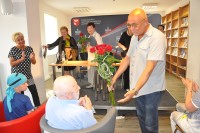 Dyrektor WBP w Olsztynie Andrzej Marcinkiewicz wrcza kwiaty autorowi sztuki Arturowi Nichthauserowi