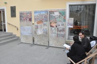 Trzy plansze z wystaw w atrium Starego Ratusza, po prawej dwaj czytelnicy siedzcy na leakach WBP