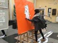 Uczestniczka akcji nakleja karteczk z liter swojego pokolenia na du pomaraczow tablic symbolizujc map pokole