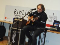 Cezary Makiewicz gra na gitarze i piewa