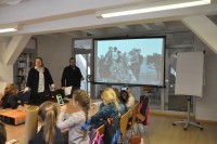Rafa Maindl i Joanna Black Maindl pokazuj dzieciom stare zdjcie, na ktrym znajduj si ludzie i konie.