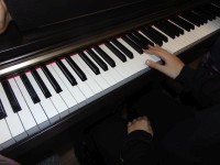 Ucze prbuje zagra na elektronicznym pianinie. 