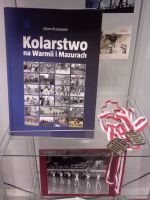 Fragment ekspozycji w szklanej gablocie: ksika Adama Brzozowskiego „Kolarstwo na Warmii i Mazurach” oraz dwa zote medale z Mistrzostw Gimnazjw Miasta Olsztyna 1998 i 1999 r.