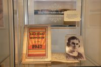 Fragment ekspozycji w szklanej gablocie: czarno-biae zdjcie portretowe Emilii Sukertowej oraz egzemplarz „Kalendarza dla Warmiakw na rok 1947”.