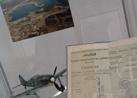 Widok na jedn z pek gabloty - model niemieckiego samolotu z czasw II wojny wiatowej, kolorowe zdjcie autorstwa Wacawa Kapusto przedstawiajce Jezioro Dugie oraz przylege osiedla z lotu ptaka i Licencja sportowa modelarza lotniczego.