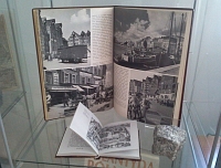 Fragment wystawy w witrynie: dwie otwarte na rycinach przedwojenne niemieckie ksiki o Krlewcu oraz kostka brukowa, symbolizujca zniszczenie miasta.