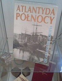 Fragment wystawy w witrynie: ustawiona pionowo ksika „Atlantyda Pnocy” oraz kostka brukowa, symbolizujca zniszczenie miasta.